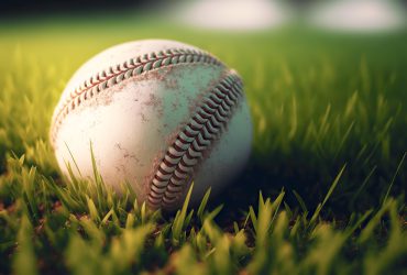 Baseball, znany jako "amerykańska gra narodowa", ma bogatą historię, która sięga kilkuset lat wstecz. Choć obecnie jest to sport o międzynarodowej renomie, jego początki są związane głównie z rozwojem w Stanach Zjednoczonych. Przez lata ewoluował, zyskując unikalne zasady i formę, która przyciąga miliony fanów na całym świecie. Początki baseballa Pierwsze wzmianki o grach podobnych do baseballa pochodzą z XVIII wieku. Te gry, takie jak rounders i town ball, były popularne w Wielkiej Brytanii, skąd przybyły do Ameryki Północnej. Baseball w swojej obecnej formie zaczął kształtować się w pierwszej połowie XIX wieku w Stanach Zjednoczonych. W 1845 roku Alexander Cartwright stworzył pierwszy zestaw zasad gry, które stały się fundamentem dla nowoczesnego baseballa. Mit Abnera Doubledaya Popularny, lecz nieprawdziwy, jest mit przypisujący Abnerowi Doubledayowi wynalezienie baseballa. Mimo że ta legenda jest szeroko rozpowszechniona, rzeczywistość wskazuje na bardziej ewolucyjny rozwój tego sportu, który czerpał z różnych gier europejskich i amerykańskich. Rozwój lig baseballowych Pierwsza zawodowa drużyna baseballowa, Cincinnati Red Stockings, powstała w 1869 roku, co stanowiło kamień milowy w historii tego sportu. Wkrótce potem, w 1876 roku, utworzono National League, która jest jedną z głównych lig baseballowych w USA do dzisiaj. Powstanie profesjonalnych lig przyczyniło się do szybkiego wzrostu popularności baseballa. Historia baseballa jest pełna legendarnych zawodników, którzy przyczynili się do jego popularności. Babe Ruth, znany jako "Sultan of Swat", ustanowił wiele rekordów, które przetrwały dekady. Inne ikony, takie jak Joe DiMaggio, Willie Mays i Hank Aaron, również odcisnęły swoje piętno na historii tego sportu. Aby dowiedzieć się więcej o baseballu, zapraszamy na blog.etoto.pl. Wpływ na kulturę i społeczeństwo Baseball szybko stał się integralną częścią amerykańskiej kultury. Mecze baseballowe przyciągały tłumy, stając się miejscem spotkań społeczności. Sport ten inspirował także literaturę, muzykę i film, odzwierciedlając amerykański styl życia i wartości. Okres międzywojenny, zwany "złotą erą baseballa", to czas wielkich osiągnięć i intensywnego rozwoju tego sportu. Gwiazdy takie jak Babe Ruth i drużyny jak New York Yankees dominowały na boiskach, a baseball osiągał szczyty popularności. Baseball współczesny Obecnie baseball jest jednym z najpopularniejszych sportów w Stanach Zjednoczonych i wielu innych krajach. Major League Baseball (MLB) organizuje rozgrywki na najwyższym poziomie, a finałowy World Series przyciąga uwagę fanów z całego świata. Mimo zmian technologicznych i strategii, duch i tradycje baseballa pozostają niezmienne. Baseball nieustannie się rozwija, przyciągając nowe pokolenia graczy i fanów. Jego przyszłość wygląda obiecująco, z coraz większą globalną obecnością i rosnącym zaangażowaniem społeczeństwa. Baseball pozostaje sportem, który łączy ludzi i jest ważnym elementem dziedzictwa kulturowego Stanów Zjednoczonych.